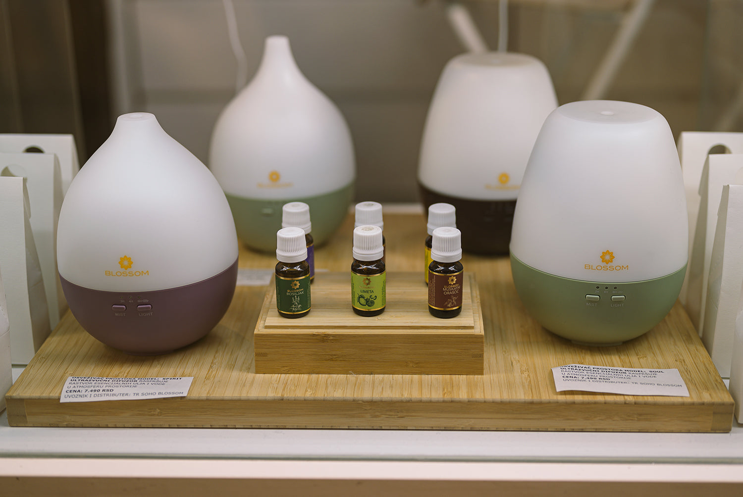 Difuzeri za eterična ulja i bočice eteričnih ulja izloženi na drvenom postolju